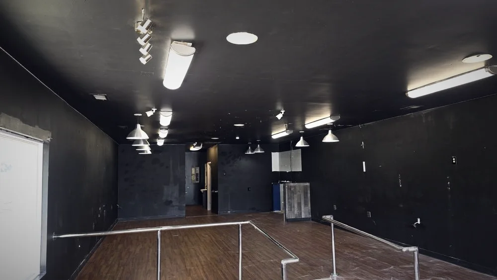A commercial space with new recessed and track lighting under a dark ceiling